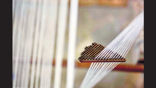 Yarn with a thread count of 350 is passed through a loom’s thread separator. ‘We are still learning to work with such fine yarn. It’s maddening in some ways,’ says researcher Saiful Islam, laughing. (Tapash Paul / Drik-Bengal Muslin)