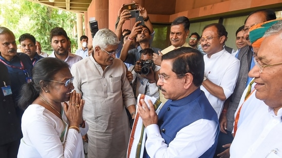 Droupadi Murmu being welcomed by Parliamentary Affairs Minister Pralhad Joshi as she arrives at Parliament House to file her nomination papers.(PTI)