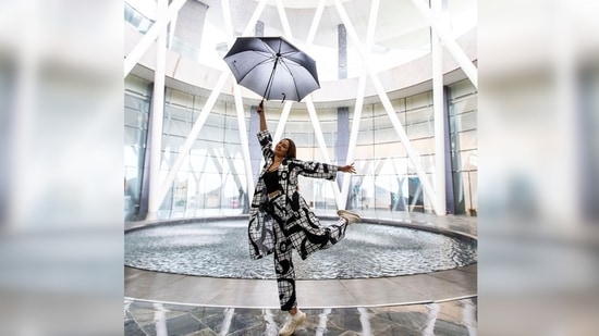 Sonakshi Sinha shows her goofy side as she strikes a happy pose holding an umbrella and lifting her leg.&nbsp;(Instagram/@aslisona)
