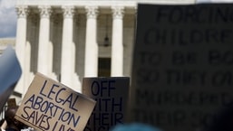 bortion rights activists hold signs during a protest in front of the Supreme Court building following the announcement to the Dobbs v Jackson Women's Health Organization ruling on June 25, 2022 in Washington, DC. 