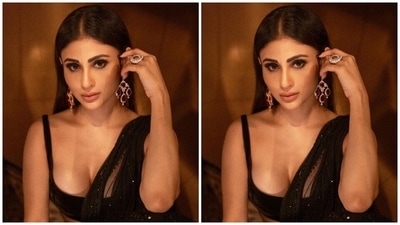Mouni's short sleeveless blouse comes in a black-hued velvety fabric and features a decolletage-flaunting plunging neckline, strapped sleeves and a cropped hem length showing off her toned midriff. (Instagram) Mouni's short sleeveless blouse comes in a black-hued velvety fabric and features a decolletage-flaunting plunging neckline, strapped sleeves and a cropped hem length showing off her toned midriff. (Instagram)