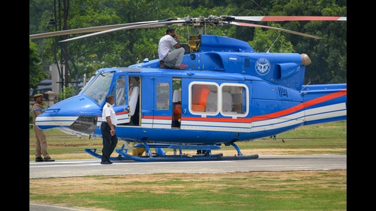 Technical staff checks the helicopter of Uttar Pradesh Chief Minister Yogi Adityanath following its emergency landing after it hit a bird, in Varanasi, Sunday. (PTI)