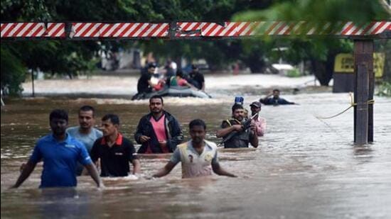 People walk through flooded Streets of Sangli, India, August 9, 2019. (Pratham Gokhale/HT Photo)