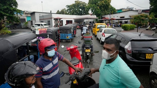 People wait in a long queues to buy fuel for their vehicles at a filling station in Colombo, Sri Lanka.