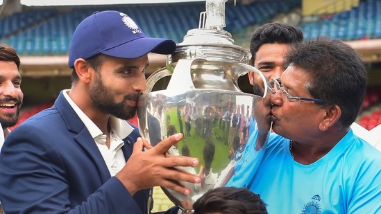 Madhya Pradesh's captain Aditya Shrivastava and head coach Chandrakant Pandit kiss the trophy after winning their final Ranji Trophy cricket match against Mumbai, at M Chinnaswamy Stadium in Bengaluru.(PTI)