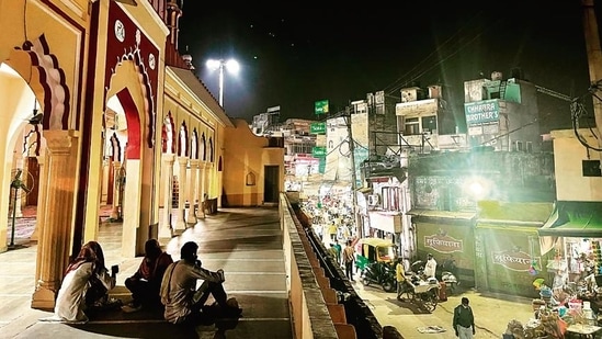 The facing gallery looks to a deserted part of the market, with an eatery lit up by a jhalar of red bulbs.