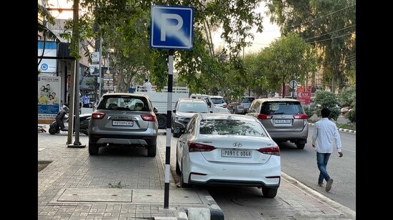 Vehicles parked on the cycling track established at Malhar Road in Ludhiana under the Smart City Mission. (Gurpreet Singh/HT)