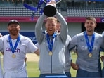 England's Ben Stokes celebrates with the trophy and teammates after winning the match and the series vs New Zealand.