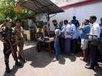 Army soldiers and a police officer secure a fuel station as people register themselves to purchase fuel in Colombo, Sri Lanka.