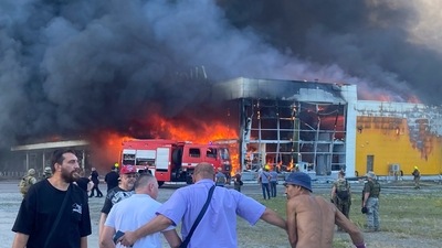 People watch as smoke bellows after a Russian missile strike hit a crowded shopping mall, in Kremenchuk, Ukraine. (AP) People watch as smoke bellows after a Russian missile strike hit a crowded shopping mall, in Kremenchuk, Ukraine. (AP)