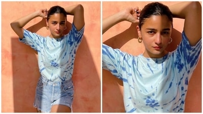 Alia championed tie-dye fashion in this sunkissed photoshoot by opting for a half-sleeve top and denim shorts with frayed hems. The set came in varying shades of blue, and Alia styled it with a sleek bun, gold hoop earrings, and a no-makeup look. (Instagram) Alia championed tie-dye fashion in this sunkissed photoshoot by opting for a half-sleeve top and denim shorts with frayed hems. The set came in varying shades of blue, and Alia styled it with a sleek bun, gold hoop earrings, and a no-makeup look. (Instagram)