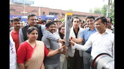 The relay torch being handed over to be carried to Varanasi from Prayagraj on Monday. (HT Photo) The relay torch being handed over to be carried to Varanasi from Prayagraj on Monday. (HT Photo)