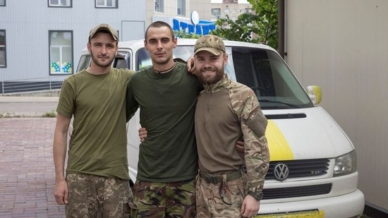 Anton (R), um soldado que voltou de Sievierodonetsk, posa para uma foto com seu amigo.(REUTERS)