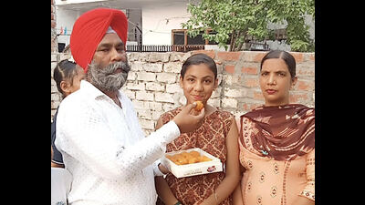 Arshdeep Kaur, the state topper, celebrating with her family in Ludhiana on Tuesday. (HT Photo)