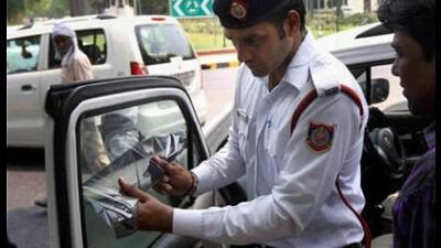 Traffic cop issuing challan to a commuter. (File Photo) Traffic cop issuing challan to a commuter. (File Photo)