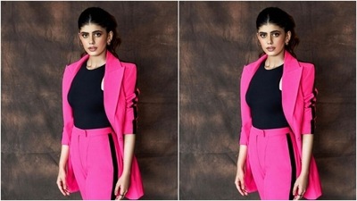 Sanjana paired a black tank top with a bright pink blazer with lapel collars and a black stripe at the sleeves. She teamed it with a pair of formal trousers with high waists and wide legs. (Instagram/@sanjanasanghi96)