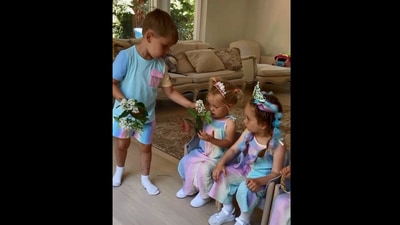 The image, taken from a viral video, showcased the brother handing out flowers to his sisters. (Instagram/@vivienneandfrancesca)