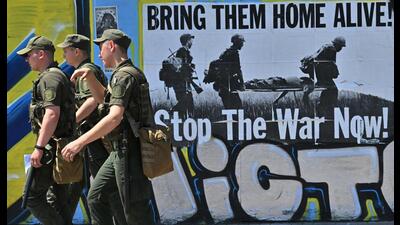 Ukrainian servicemen walk past a poster which reads "Bring them home alive! Stop the war now!" in the center of the capital of Kyiv on June 28, 2022 (AFP) Ukrainian servicemen walk past a poster which reads "Bring them home alive! Stop the war now!" in the center of the capital of Kyiv on June 28, 2022 (AFP)
