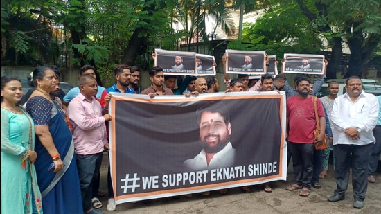 Supporters of Shiv Sena rebel Leader Eknath Shinde holds a banner reads "WE Support Eknath Shinde", in Thane on Wednesday. (Praful Gangurde)