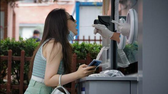 A medical worker takes a swab sample at a nucleic acid testing station, following the coronavirus disease (Covid-19) outbreak, in Beijing. (REUTERS) A medical worker takes a swab sample at a nucleic acid testing station, following the coronavirus disease (Covid-19) outbreak, in Beijing. (REUTERS)