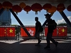 Pedestrians walks past Hong Kong and China flags, hung to mark the 25th anniversary of the Handover of Hong Kong from Britain to China which falls on July 1, in the Central district of Hong Kong (Photo by Peter PARKS / AFP) Pedestrians walks past Hong Kong and China flags, hung to mark the 25th anniversary of the Handover of Hong Kong from Britain to China which falls on July 1, in the Central district of Hong Kong (Photo by Peter PARKS / AFP)