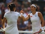 Caroline Garcia shakes hands with Emma Raducanu after winning their second round Wimbledon match.