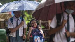 School children holding umbrellas walk in the rain, at Dadar. (Satish Bate/HT PHOTO)