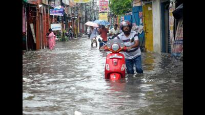 People wade through a waterlogged street in Patna on Wednesday. (Santosh Kumar/HT Photo)