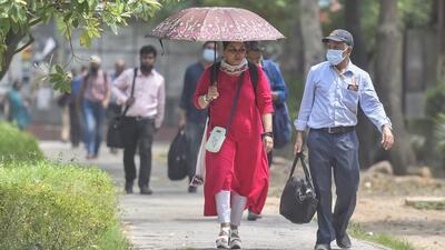 Pedestrians shield themselves from the sun on a hot summer day in New Delhi on Tuesday. (HT Photo) Pedestrians shield themselves from the sun on a hot summer day in New Delhi on Tuesday. (HT Photo)