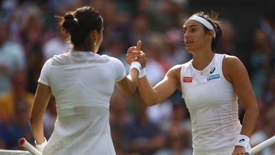 Caroline Garcia shakes hands with Emma Raducanu after winning their second round Wimbledon match. (REUTERS)