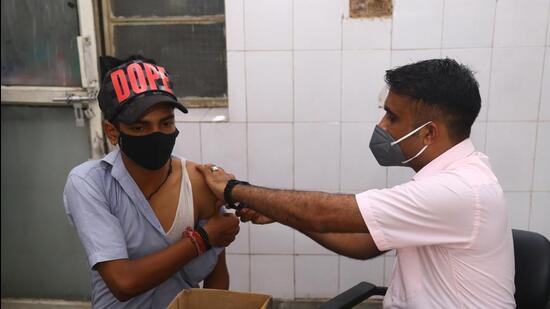 A health worker administers a Covid-19 vaccine to a beneficiary at MMG Hospital in Ghaziabad on Wednesday. (Sakib Ali /HT)