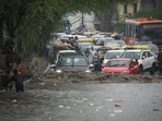 Commuters and vehicles wade through a waterlogged stretch in the National Capital Region..