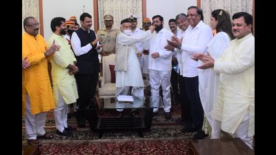Governor Bhagat Singh Koshyari offers sweets to Shiv Sena party leader Eknath Shinde. (AFP) Governor Bhagat Singh Koshyari offers sweets to Shiv Sena party leader Eknath Shinde. (AFP)