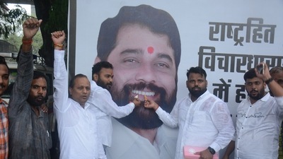 Shinde supporters offer sweets to the portrait of their leader. (Praful Gangurde/ HT photos)