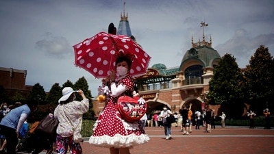 A visitor wearing a face mask poses at the Shanghai Disney Resort, as the Shanghai Disneyland theme park reopens after being shut for the coronavirus disease (Covid-19) outbreak, in Shanghai, China June 30, 2022. &nbsp; (REUTERS/Aly Song)