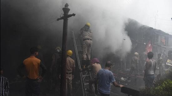 Fire brigade personnel try to douse the fire at Hathua market in Patna on Thursday. (HT Photo/ Santosh Kumar)