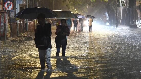 People wade through the waterlogged road near the Andheri subway on Thursday. Vijay Bate/HT Photo