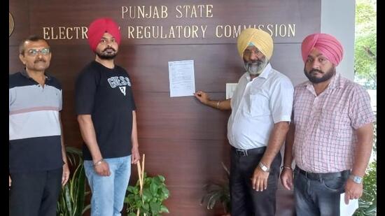 Traders pasting the memorandum outside the office of the PSERC chairperson in Chandigarh on Thursday. (HT Photo)