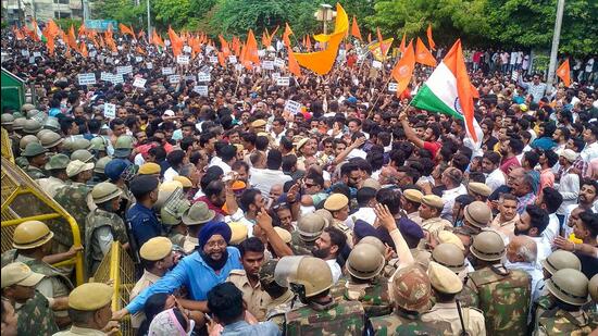 Police personnel in a scuffle with members of Sarva Hindu Samaj during their protest in Udaipur on Thursday. (PTI)