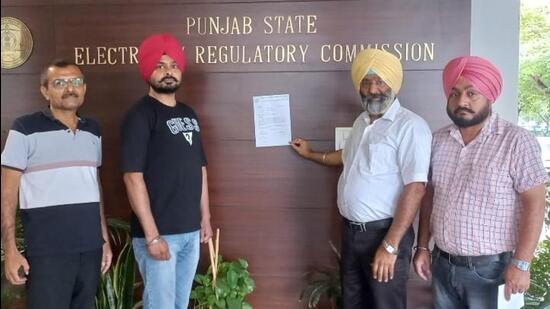 Traders pasting the memorandum outside the office of PSERC chairperson in Chandigarh on Thursday. (HT Photo)