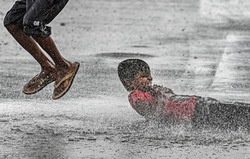 Boys play on a waterlogged road amid monsoon rains, in New Delhi, on June 30, 2022(PTI)