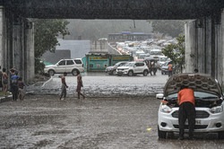 A man tries to repair his car as vehicles stuck in a heavy traffic jam on a road amid monsoon rains, in New Delhi, on June 30, 2022.&nbsp;(PTI)