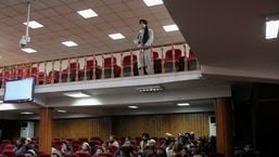 A Taliban fighter stands guard at a news conference about a new command of hijab by Taliban leader Mullah Haibatullah Akhundzada, in Kabul, Afghanistan.