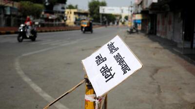 A placard reading "Will not tolerate jehadi terrorism" is tied to a barrier in a deserted road during restrictions imposed by authorities after the death of Kanhaiya Lal, a Hindu tailor killed by two after they videoed themselves slaying him, in Udaipur (REUTERS)