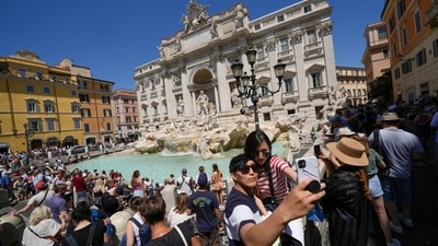 Tourists take a selfie in front of the Trevi Fountain, in Rome. Summer travel is underway across the globe but a full recovery from two years of coronavirus could last as long as the pandemic itself. In Italy, tourists — especially from the US — returned this year in droves. (AP Photo/Andrew Medichini) Tourists take a selfie in front of the Trevi Fountain, in Rome. Summer travel is underway across the globe but a full recovery from two years of coronavirus could last as long as the pandemic itself. In Italy, tourists — especially from the US — returned this year in droves. (AP Photo/Andrew Medichini)