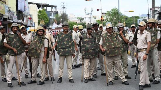 Police stand guard during a protest rally against the tailor’s killing. (AFP) Police stand guard during a protest rally against the tailor’s killing. (AFP)