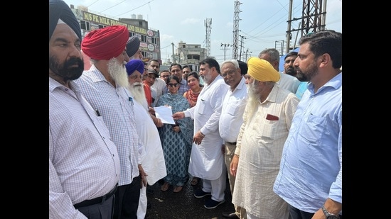 MLA Ashok Prashar Pappi and MC commissioner Shena Aggarwal interacting with members of the transporters union in Ludhiana on Friday. (HT Photo)