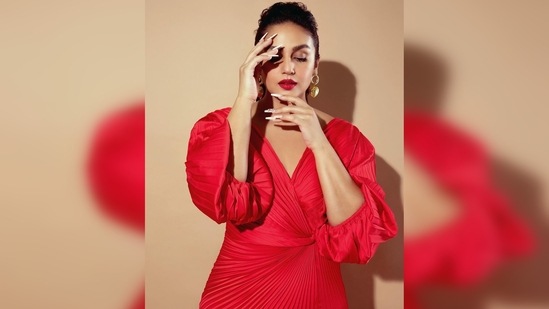 Huma Qureshi's red gown features overlapped twisted heat pleats, elasticated balloon sleeves and a thigh-high slit.(Instagram/@iamhumaq)