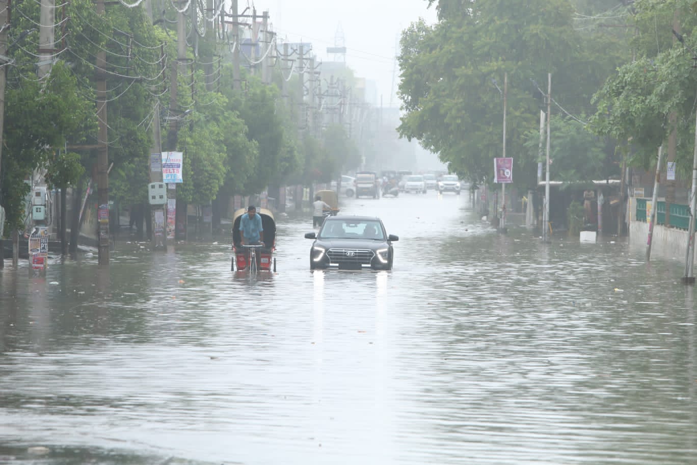 Commuters driving through an inundated Power House Road in Bathinda on Friday. (Sanjeev Kumar/HT)