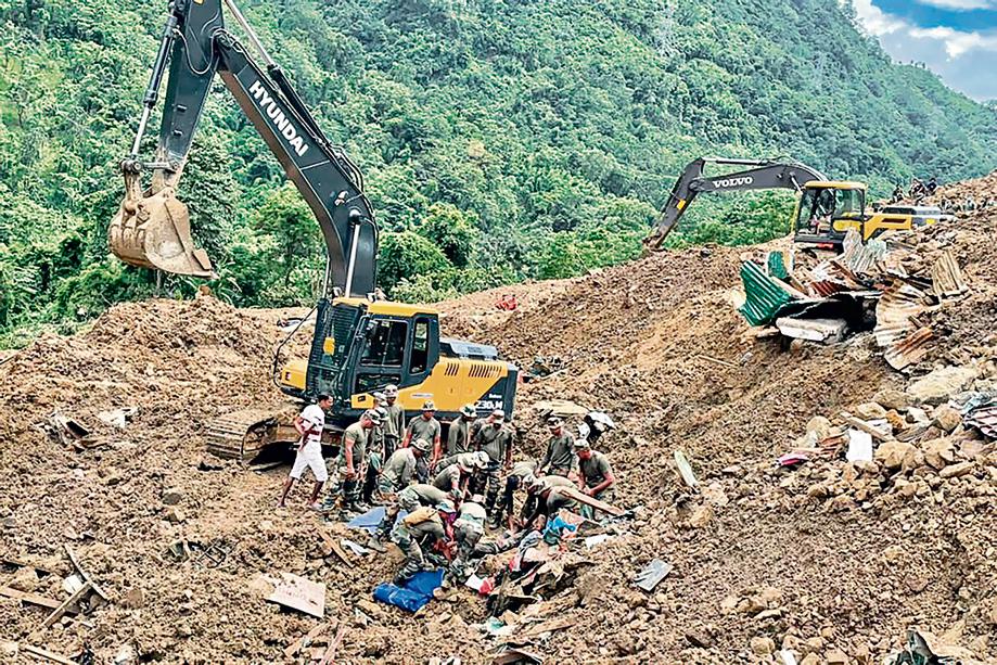 In this handout photo released by the Indian Army and taken on July 1, 2022, security forces and disaster relief teams search for survivors and victims after a landslide in Noney district, some 50 Km from Manipur's capital Imphal (Photo by INDIAN ARMY/AFP)